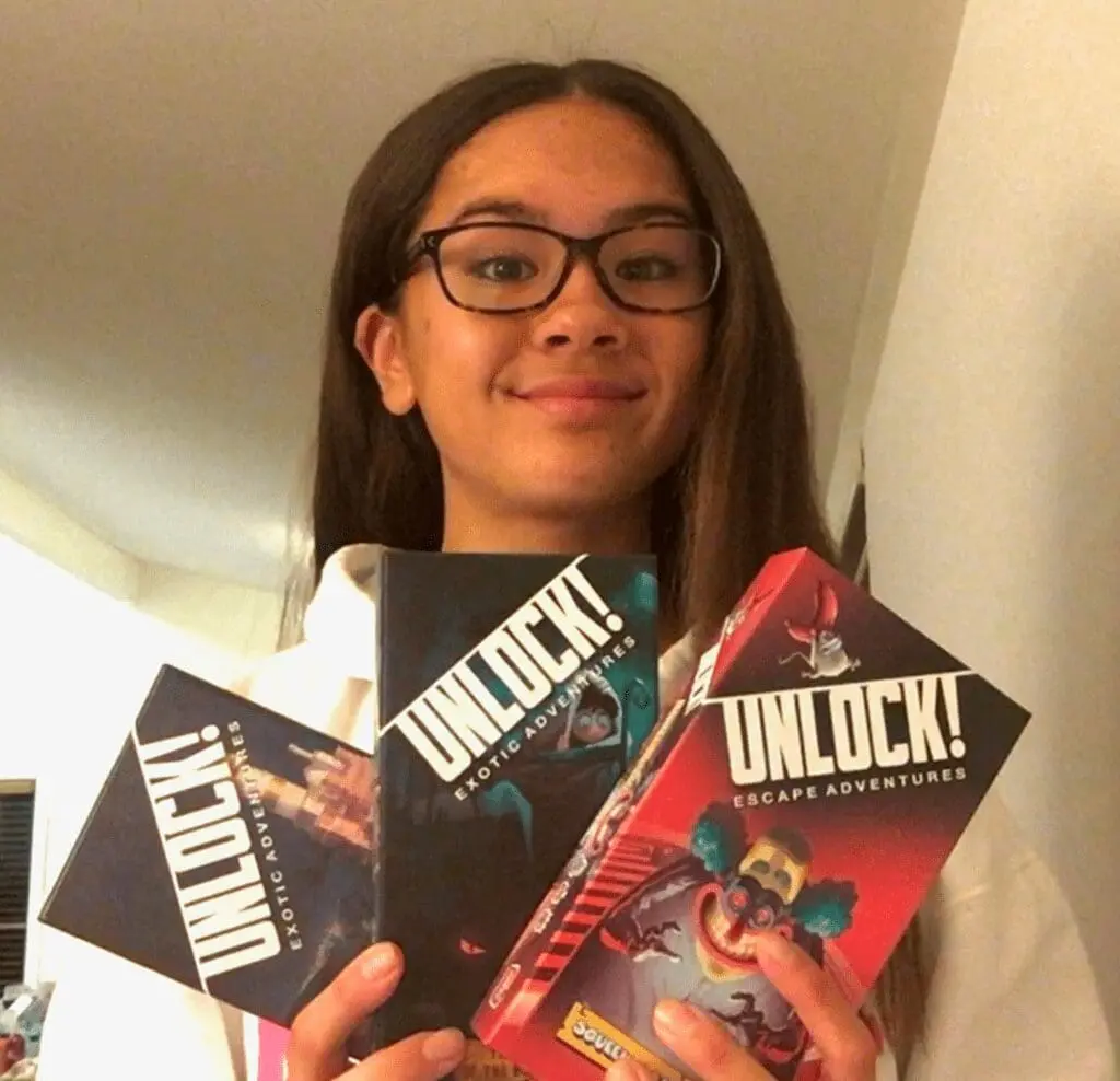 Girl holding Unlock! board games