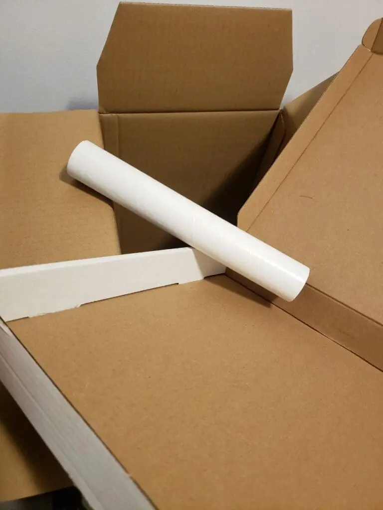 Open cardboard box with a rolled paper clue