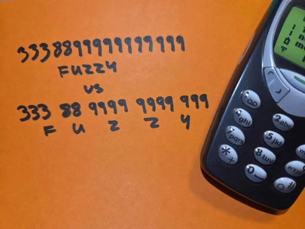 Old mobile phone with the keypad code for FUZZY, without and with spaces